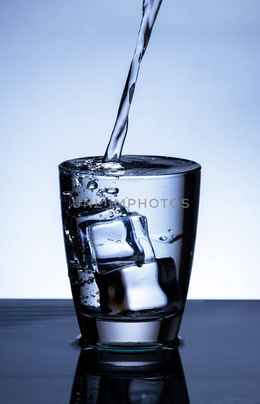 The image of pouring drinking water, into a glass, that makes one feel refreshed on blurred white background, Splashing water, Sparkling water