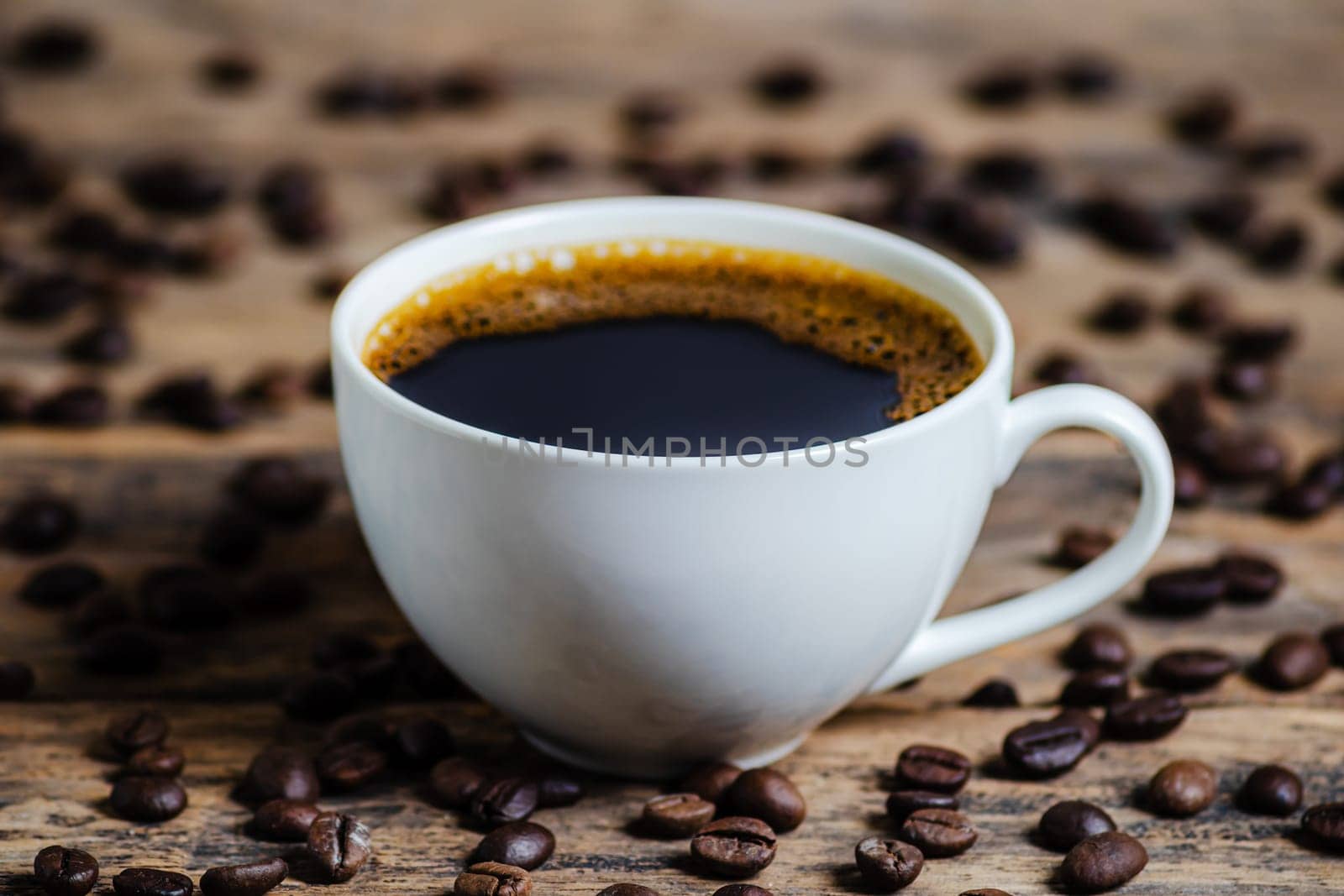 A cup of coffee with coffee bean on wooden background dark tone dtyle