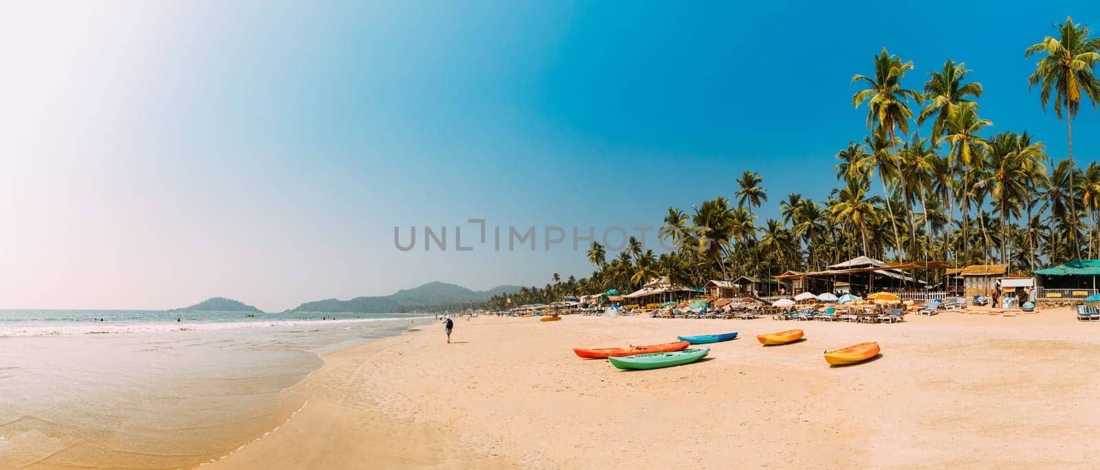 Canacona, Goa, India. Canoe Kayak For Rent Parked On Famous Palolem Beach On Background Tall Palm Tree In Summer Sunny Day.