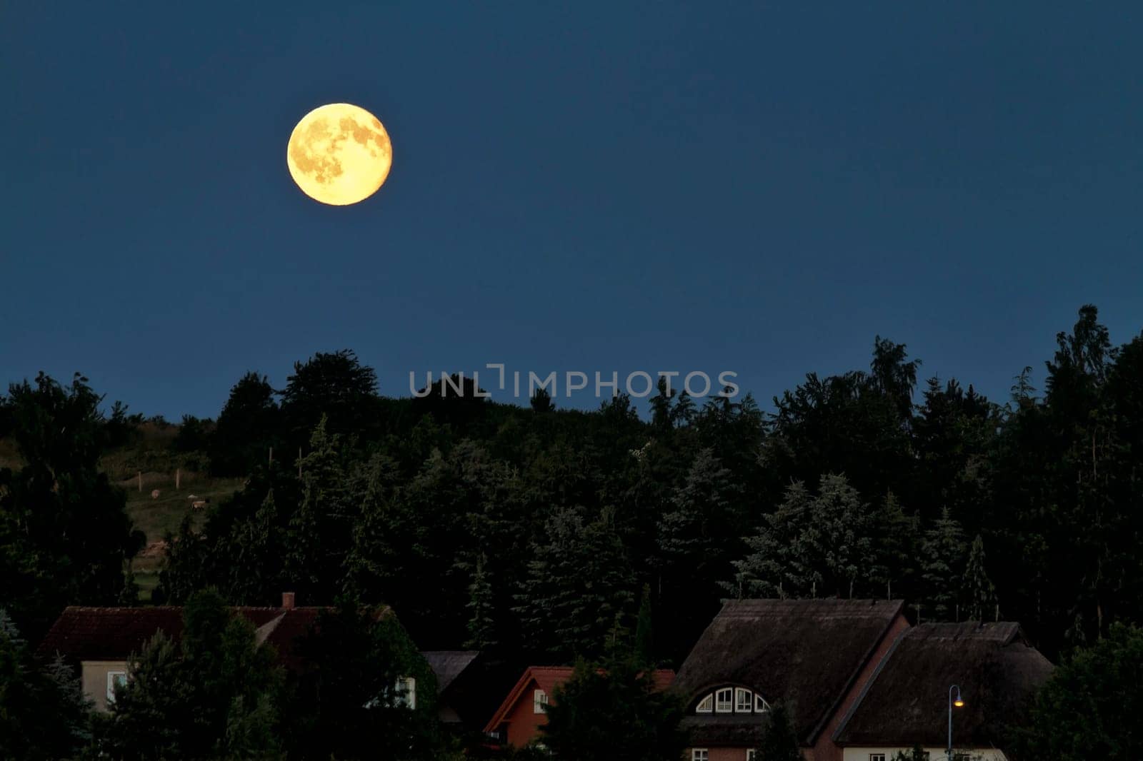 Full moon in the night sky over Alt Reddevitz/Mönchgut, island of Ruegen