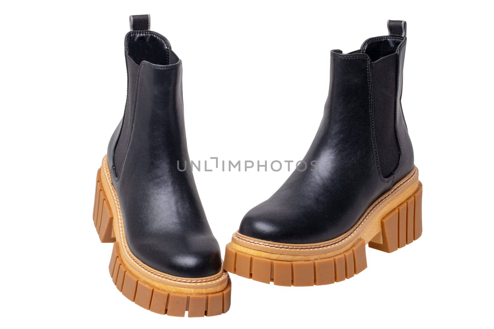 Ladies Chelsea boots. Close-up of a pair womens black leather chelsea boots with high heels isolated on a white background. Clipping path. Fashion advertisment shoes.