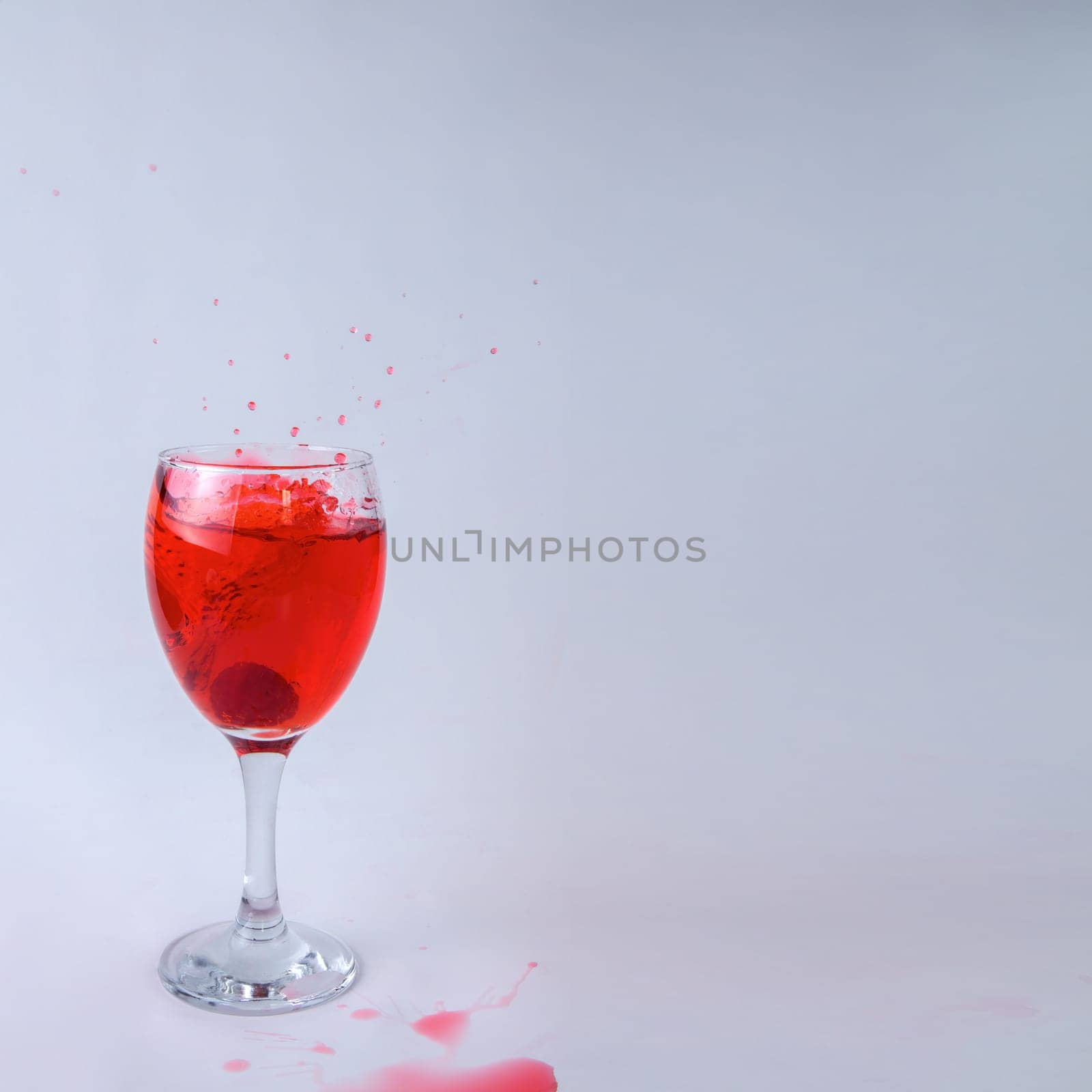 raspberry splashing into glass of wine red juice drink splash water drop on white background