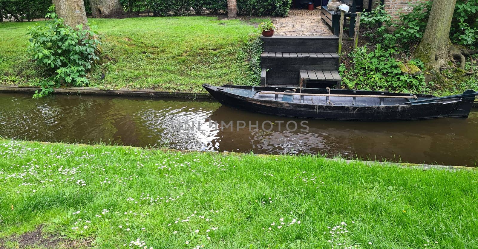 Tranquil view of the village of Giethoorn in the Netherlands, with beautiful country houses, water canals and colorful flowers