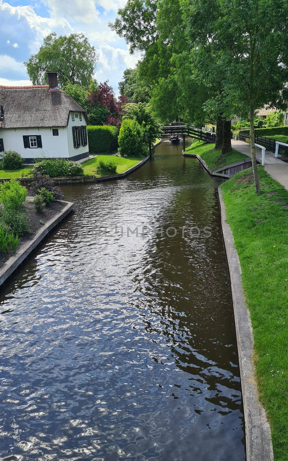 Tranquil view of the village of Giethoorn in the Netherlands, with beautiful country houses, water canals and colorful flowers
