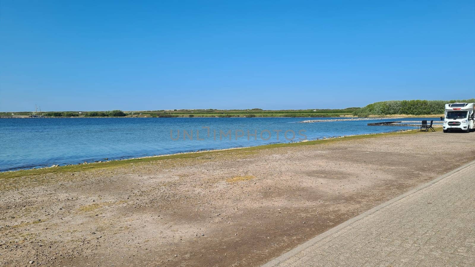View over the sea from the dune over North Sea and canal in Ouddorp, Zeeland province, The Netherlands. Outdoor scene of coast in Europe nature.