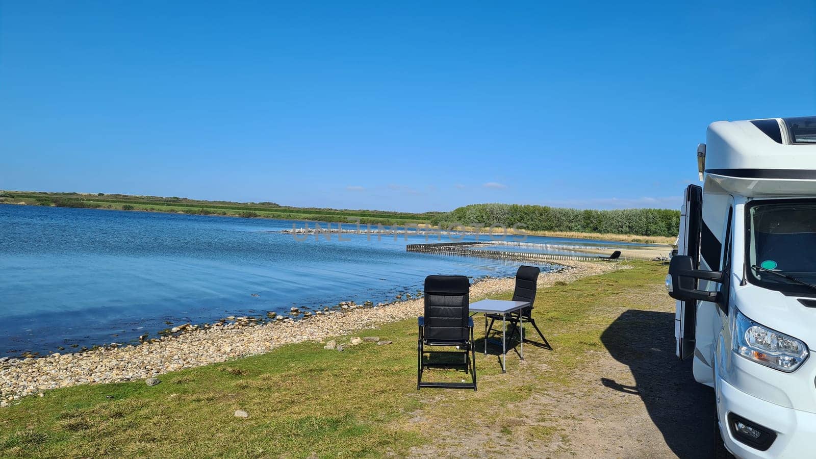 View over the sea from the dune over North Sea and canal in Ouddorp, Zeeland province, The Netherlands. Outdoor scene of coast in Europe nature.