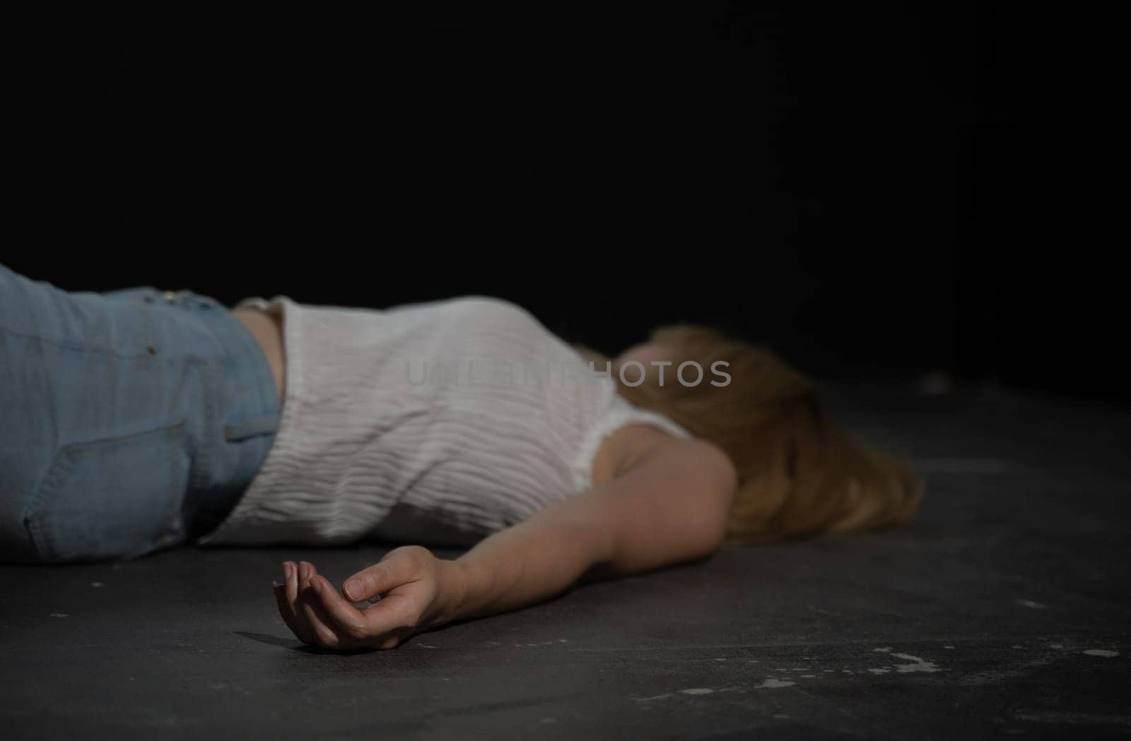 Unconscious or dead woman body lying on floor at crime scene in dark room. Murder, kill and rape people concept