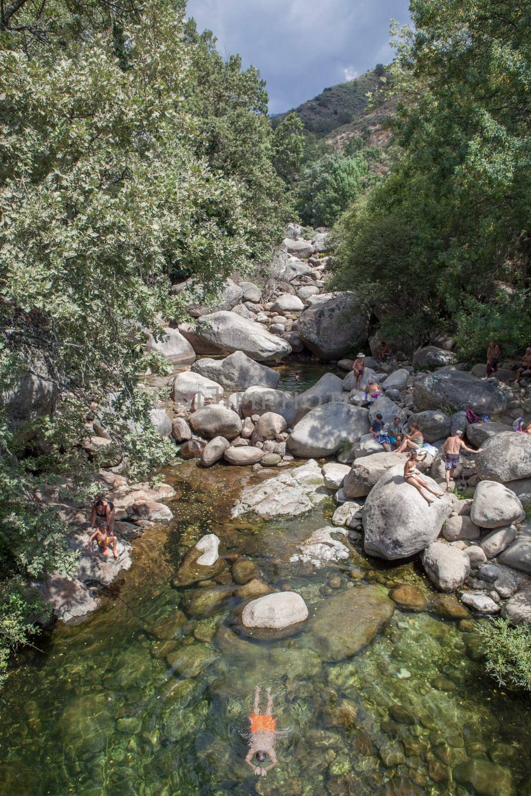 Guijo de Sta Barbara - August 25th, 2022: Visitors enjoying La Maquina Natural swimming pool, Guijo de Santa Barbara, Spain. Crystal-clear waters spot in the heart of La Vera County, Caceres, Extremadura