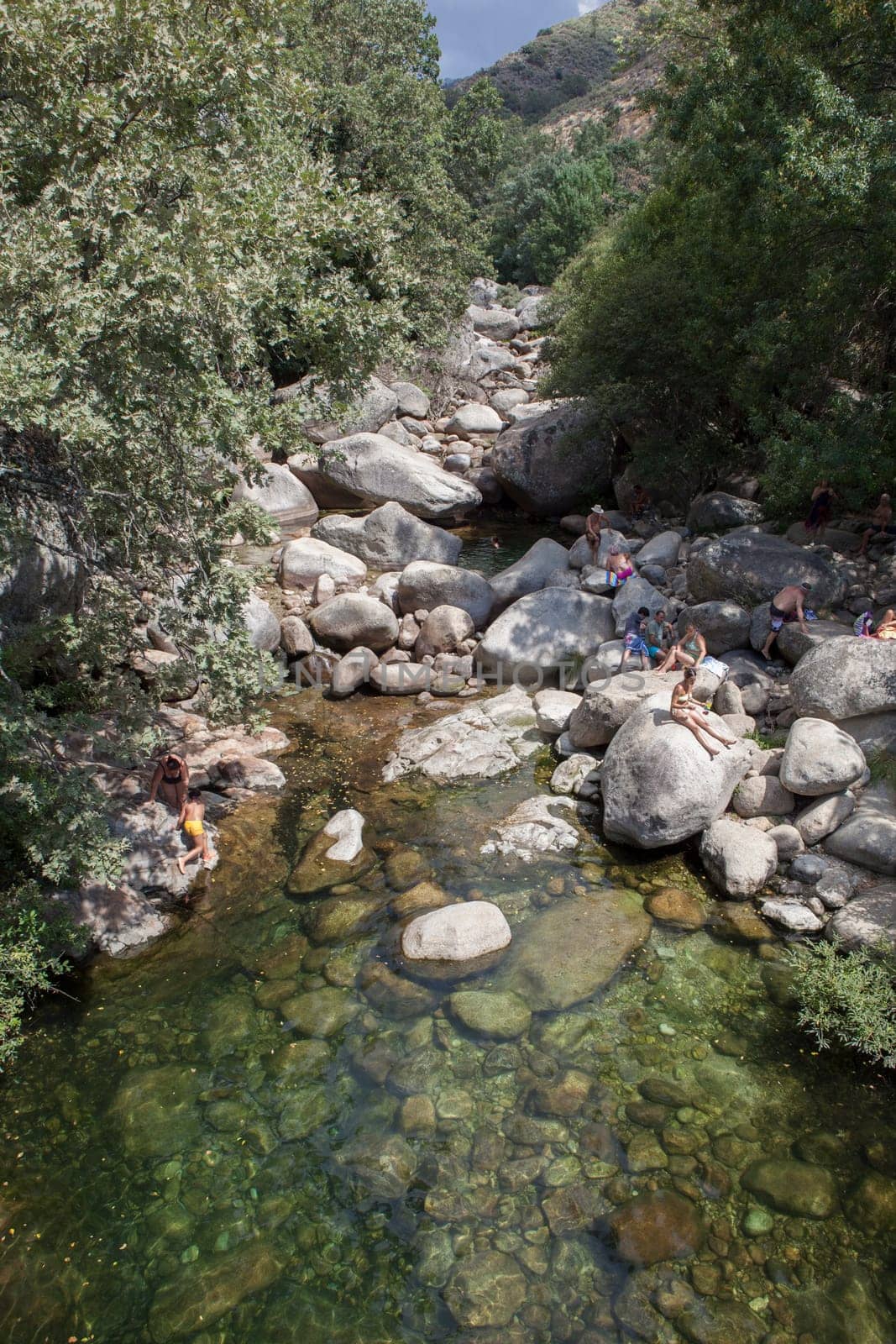 Guijo de Sta Barbara - August 25th, 2022: Visitors enjoying La Maquina Natural swimming pool, Guijo de Santa Barbara, Spain. Crystal-clear waters spot in the heart of La Vera County, Caceres, Extremadura