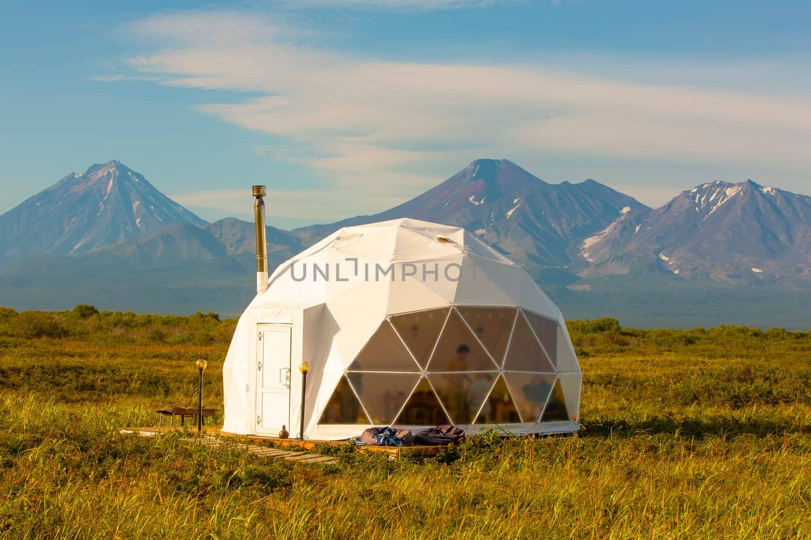 The Glamping house and volcano, rural landscape, tent houses in Kamchatka peninsula. Selective focus.