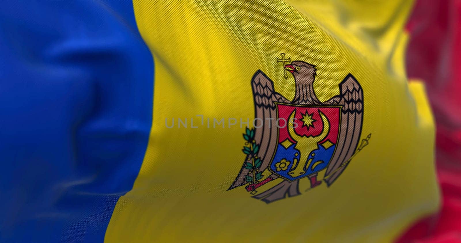 Close-up view of the Moldova national flag waving in the wind. Republic of Moldova is a landlocked country in Eastern Europe. Fabric textured background. Selective focus