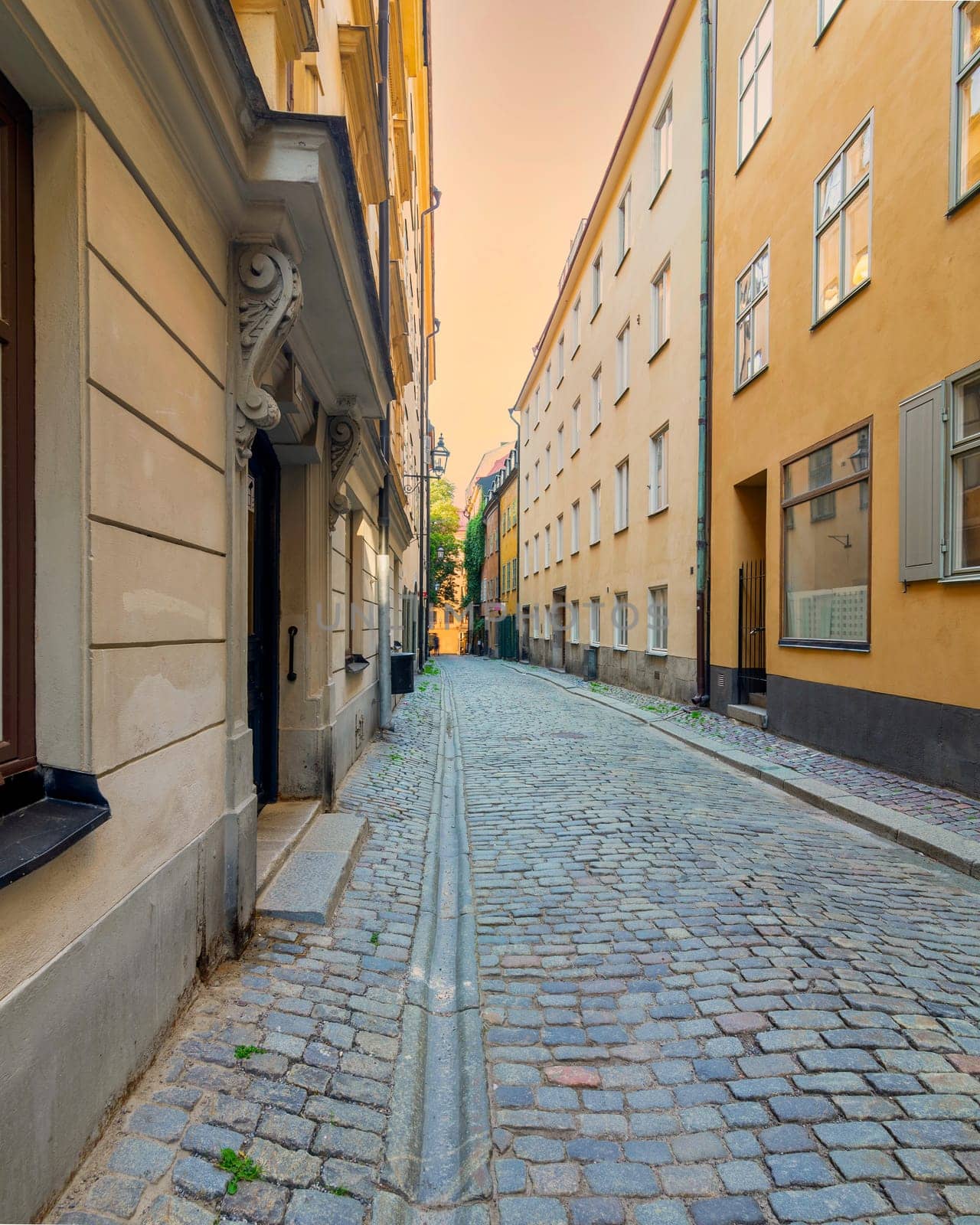Narrow alley in Gamla stan, the old town of Stockholm, Sweden, with old style orange colored houses and cobblestone street, Stockholm, Sweden