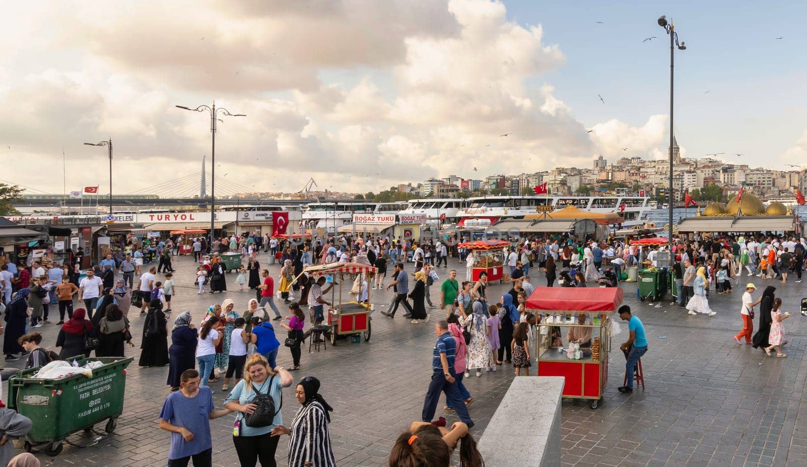 Istanbul, Turkey - August 30, 2022: Crowds of local citizens at Eminonu Piazza during the Victory Day holiday with background of Istanbul city view including Galata Tower