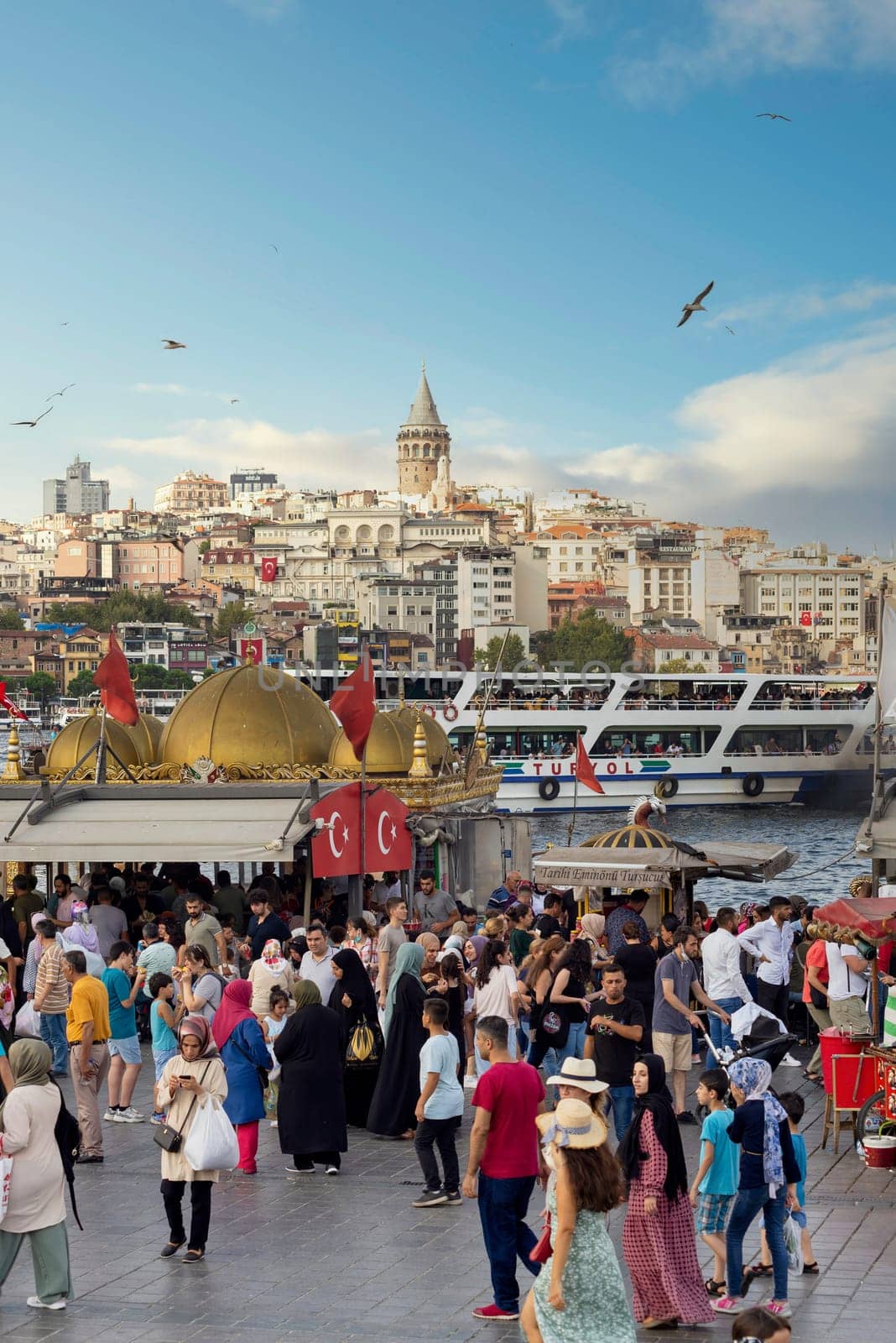 Istanbul, Turkey - August 30, 2022: Crowds of local citizens at Eminonu Piazza during the Victory Day holiday with background of Istanbul city view including Galata Tower