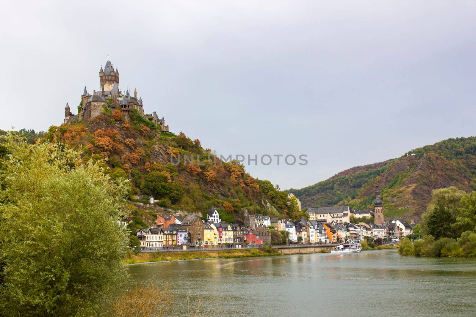 Cochem in Germany, beautiful historical town on romantic Moselle river, city view with Reichsburg castle on a hill in autumn color