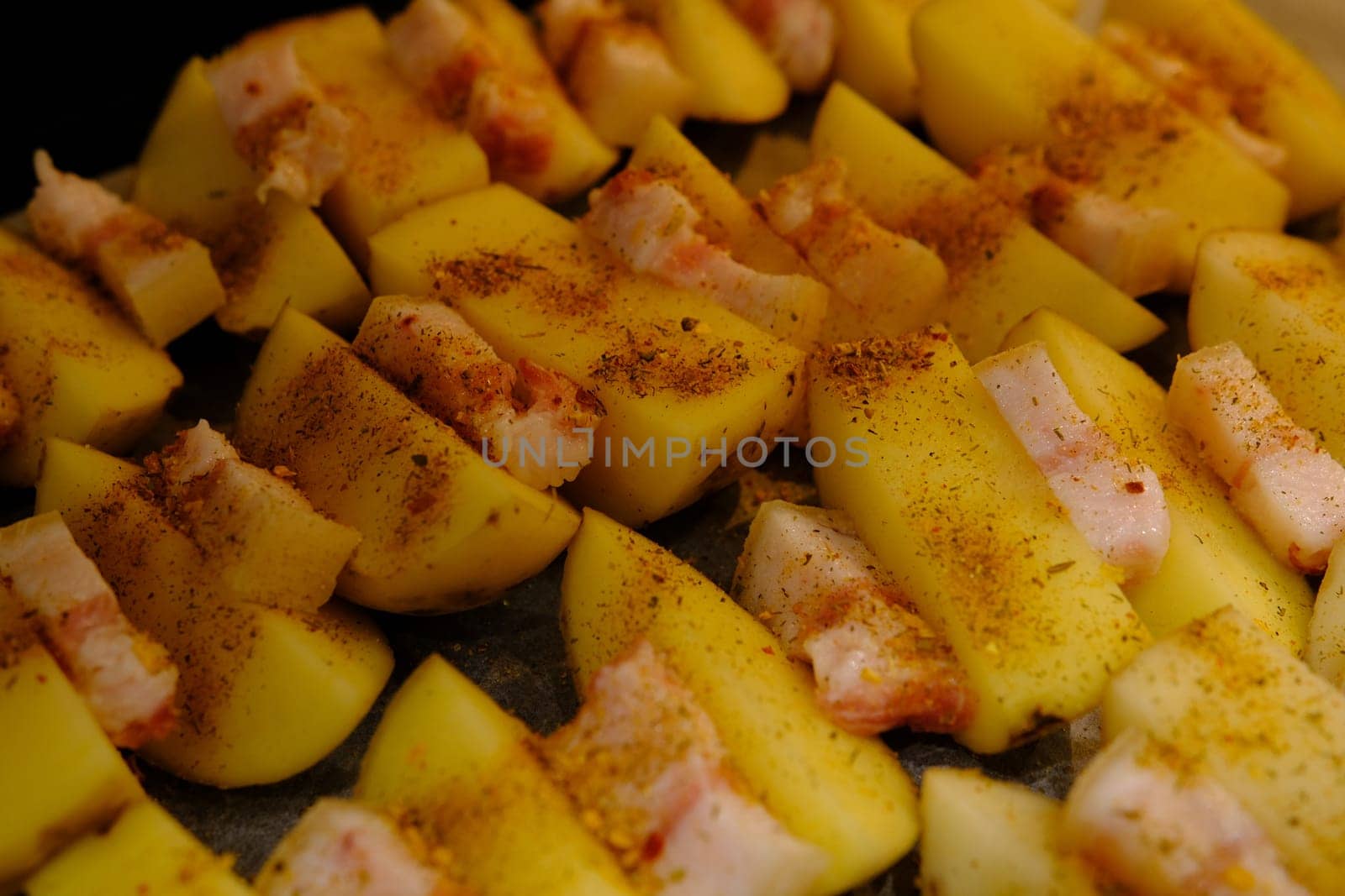 Delicious Potato Bratkartoffeln With Bacon close up in the plate on ready to bake.