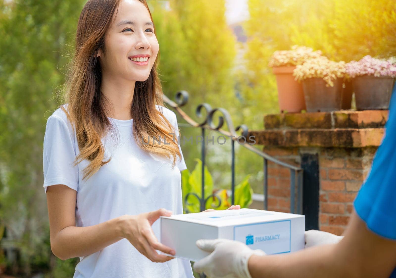 Asian woman sick she receive medication first aid pharmacy box hospital delivery service, Delivery man give medicine drug store to patient female at front home, healthcare medicine online business