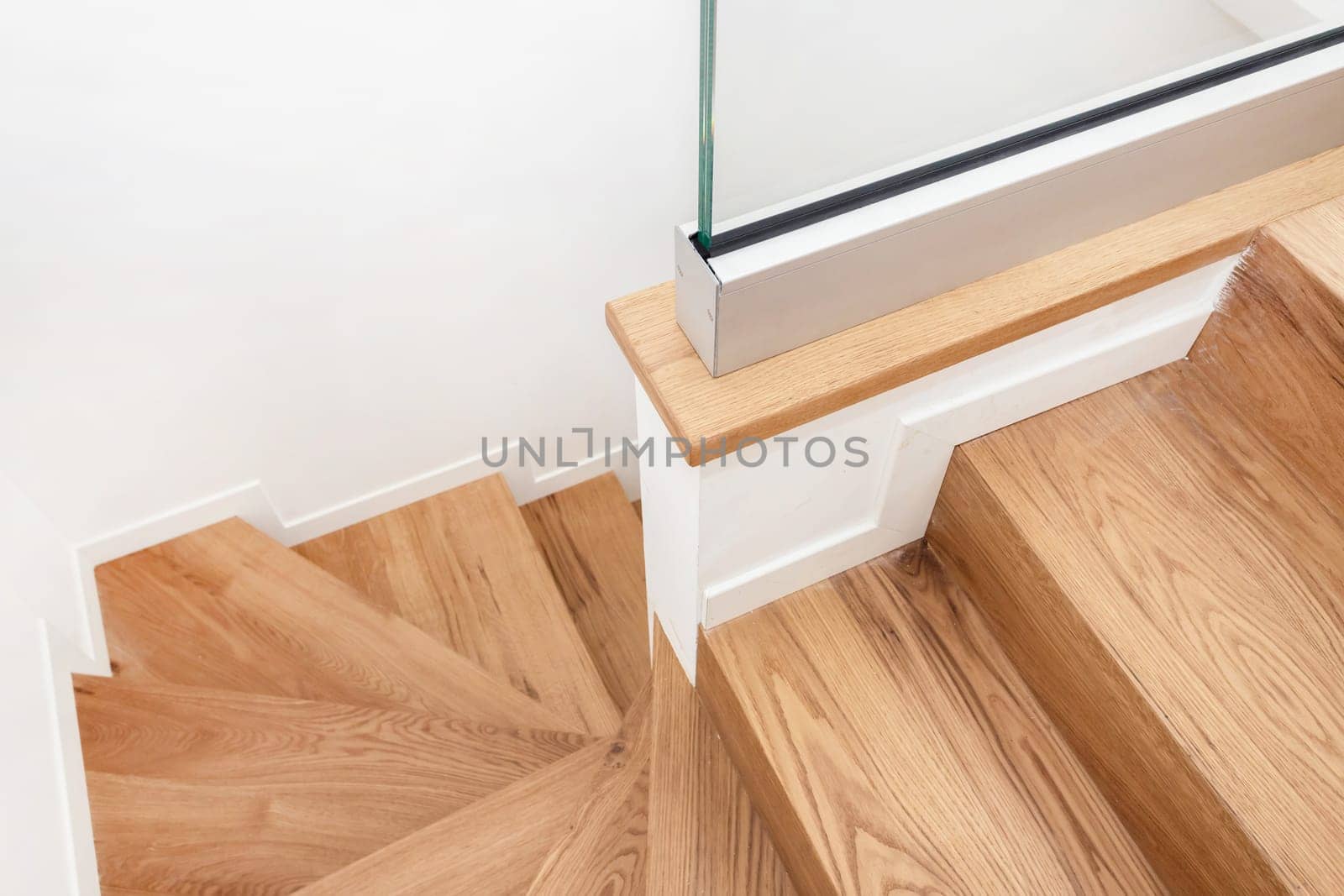 Modern residential wooden stairs. Wood staircase inside contemporary white modern house.