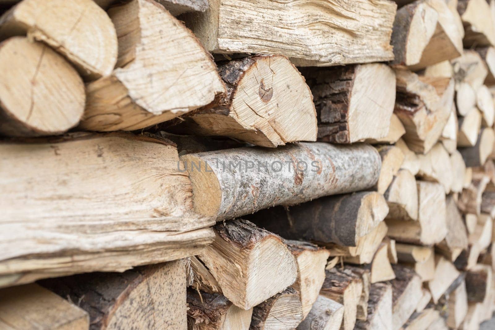 Full Frame Pile of Firewood Background Weathered Cracked Wood Texture.