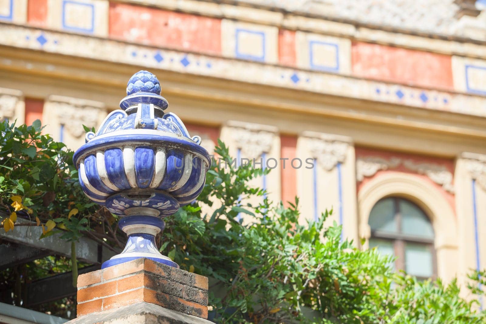 Colored ceramic top vase close to Palace of San Telmo, Seville, Andalusia, Spain. Brick wall top