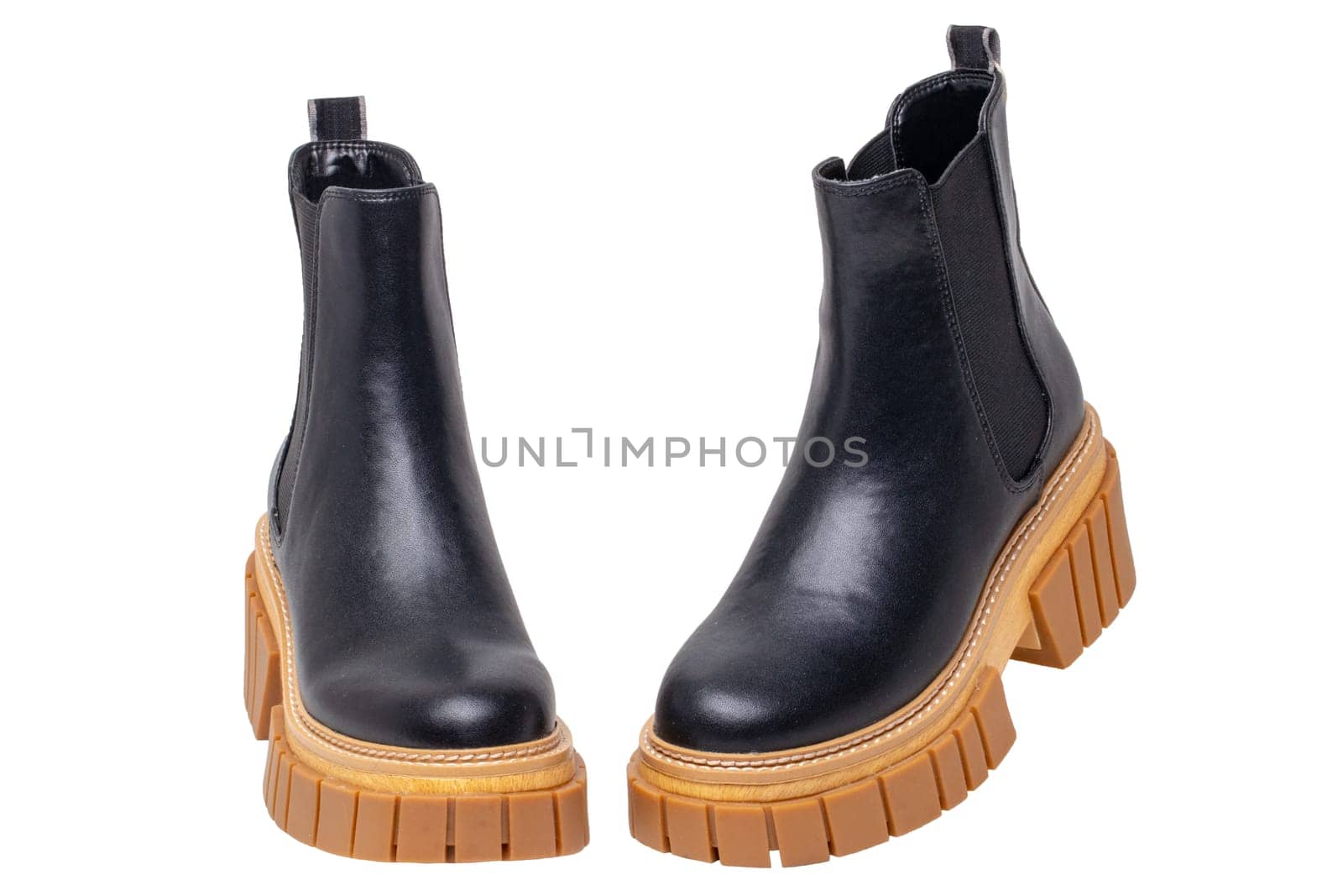 Ladies Chelsea boots. Close-up of a pair womens black leather chelsea boots with high heels isolated on a white background. Macro. Fashion advertisment shoes.