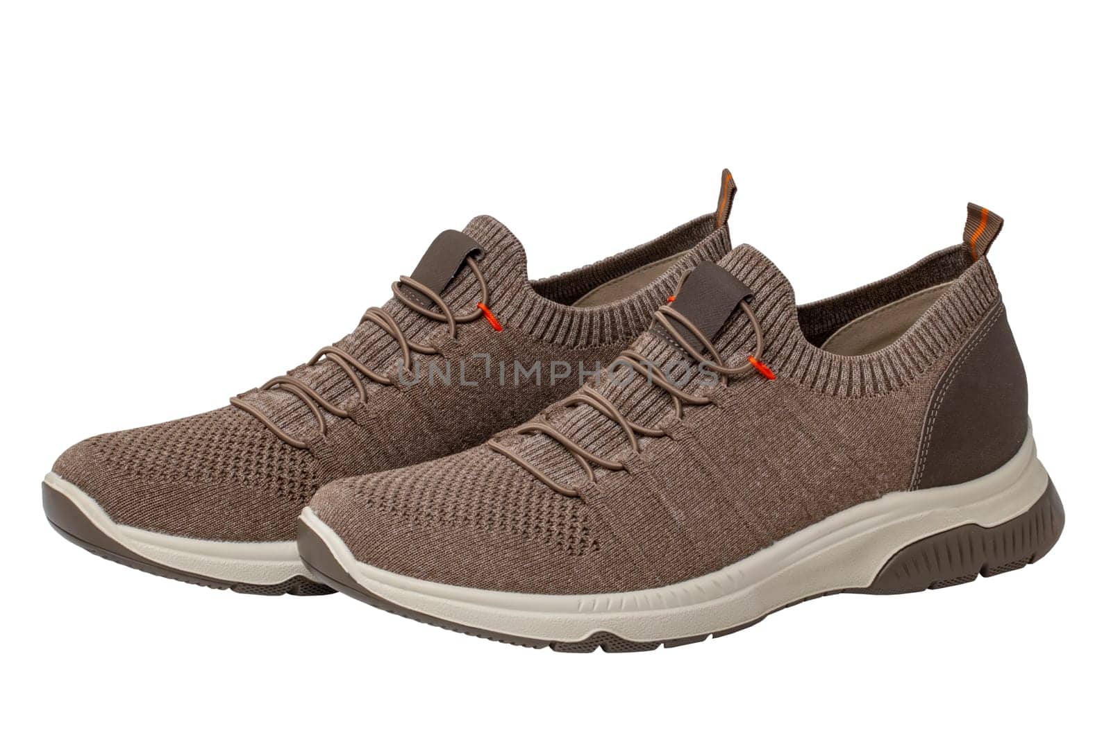 Closeup of a pair of modern brown sneakers or sports shoes isolated on a white background. Clipping path. Elegant and trendy mans shoes. Macro.