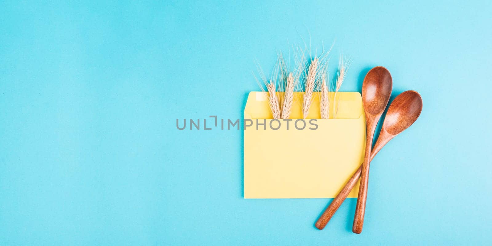 Envelope with wheat ears and empty spoons, food shortage and increasing prices, poverty through inflation