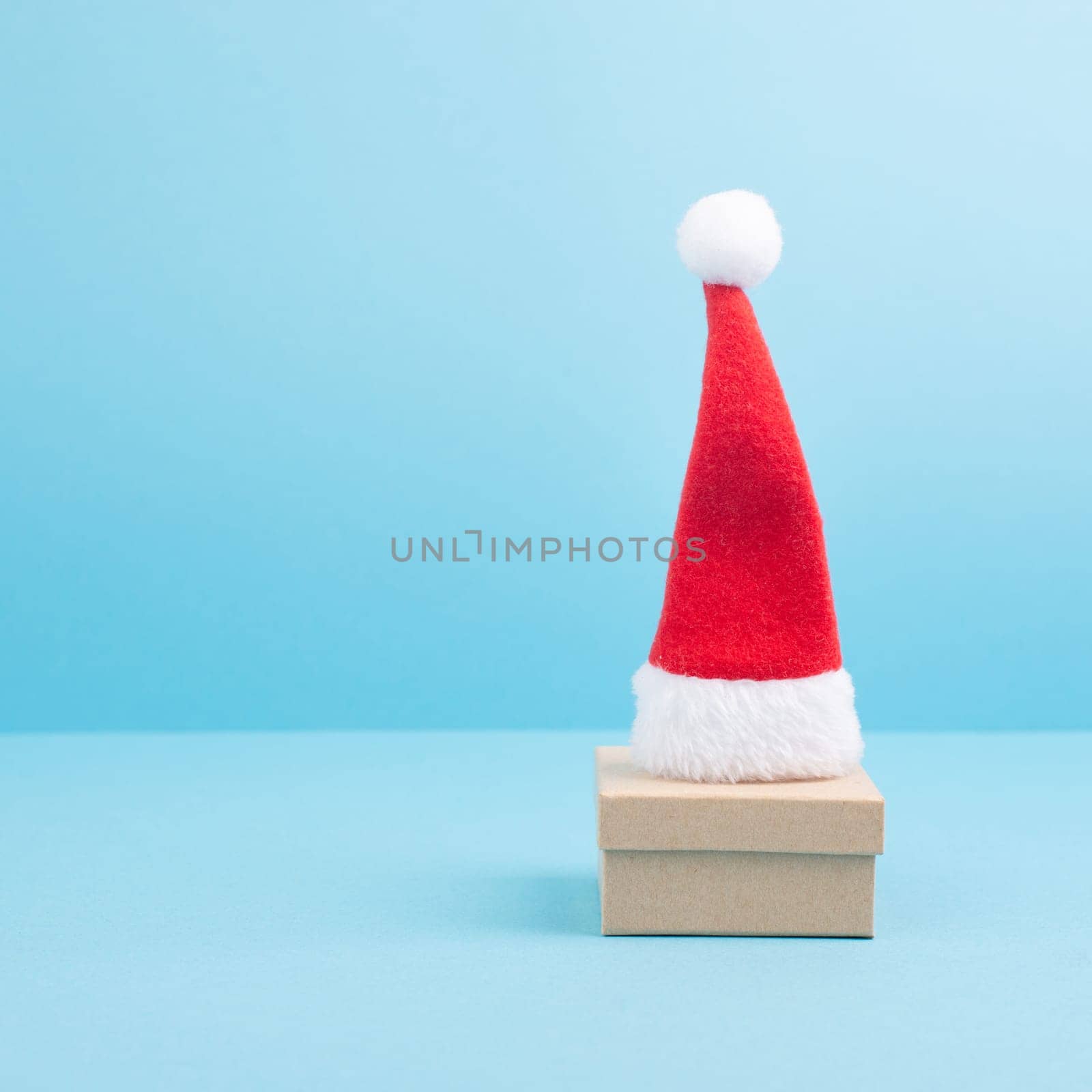 Red Santa Claus hat on a gift box, christmas and new year greeting card with copy space