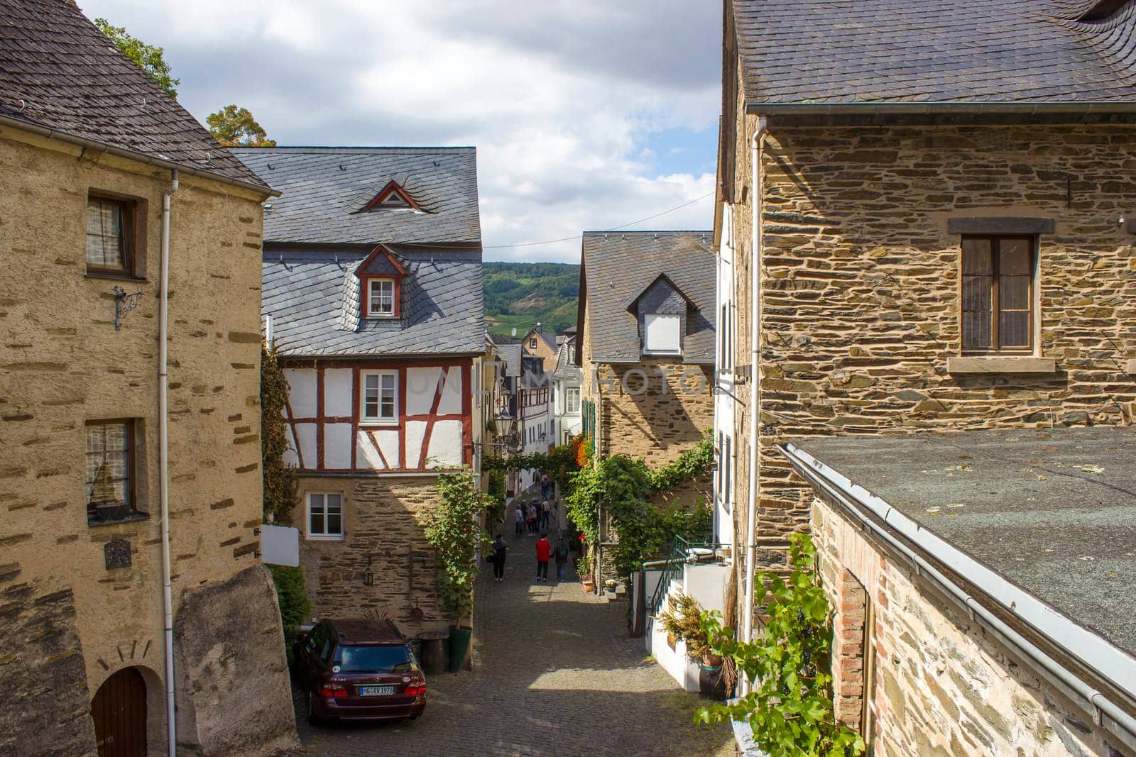 BEILSTEIN, GERMANY - SEPTEMBER 03 2022: historic village along the river Moselle with old half-timbered houses and the ruins of castle Metternich on top of the hills