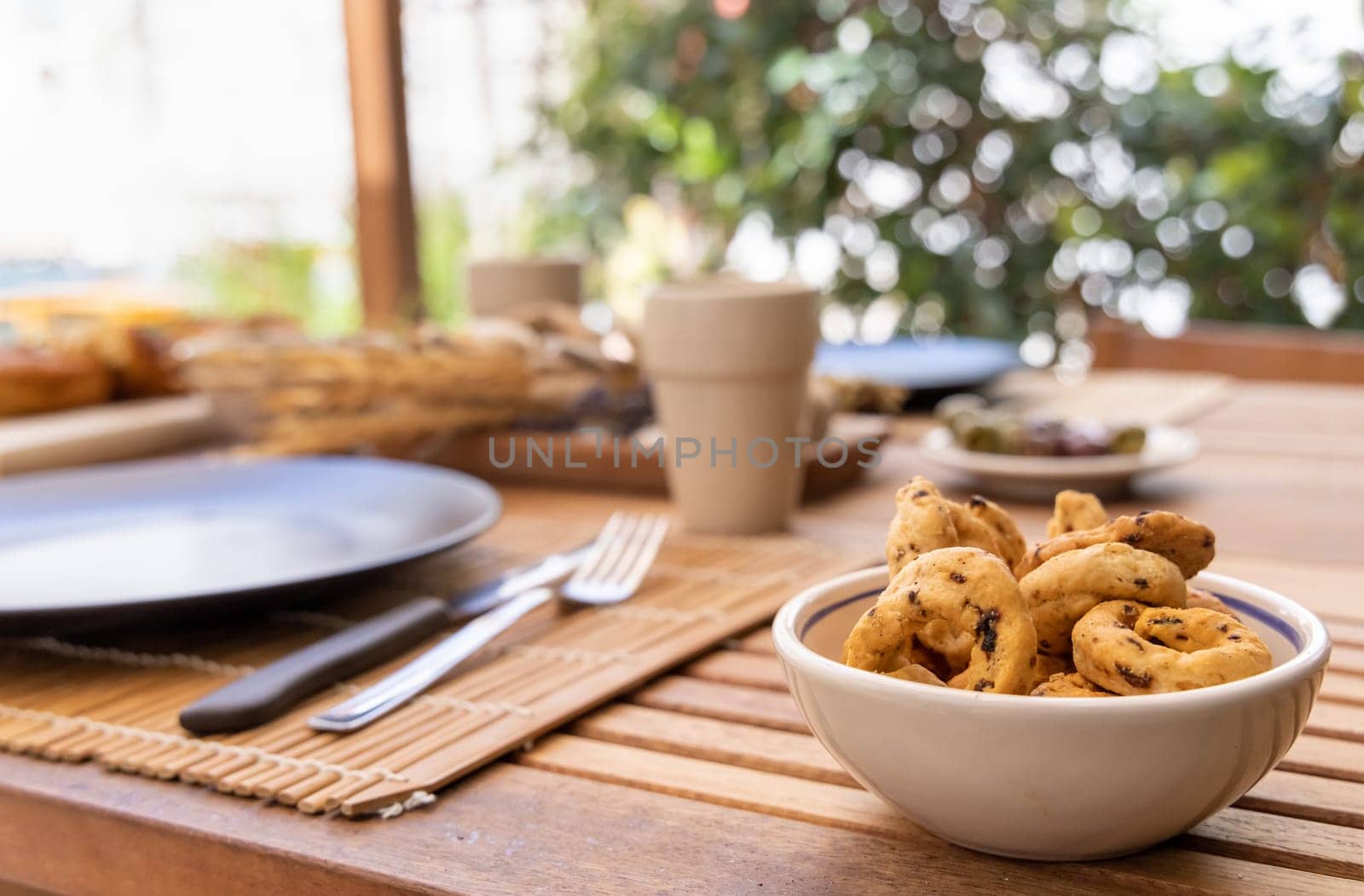 Italian summer appetizer tarallini in a bowl served outdoor with glasses of red wine. Tipical Apulian taralli made in Bari. Local cousine. Vegetarian food