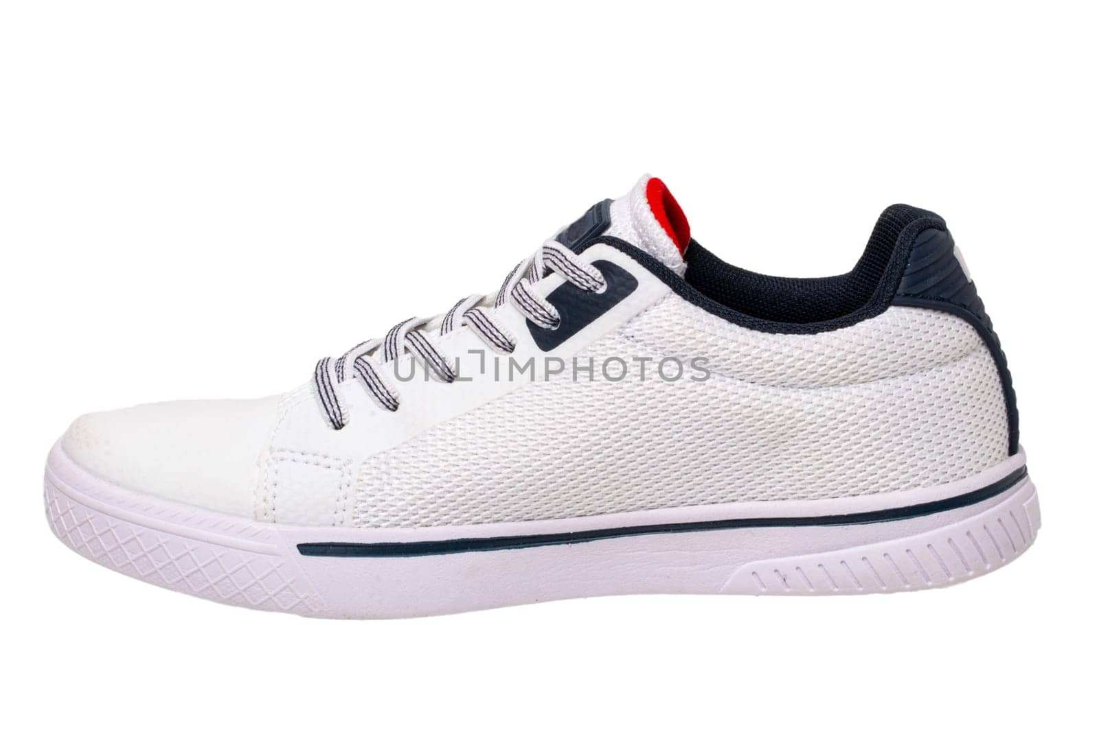 White sneakers isolated. Close-up of a single white elegant stylish leather sport shoe isolated on a white background. Modern design footwear for workout. Macro.