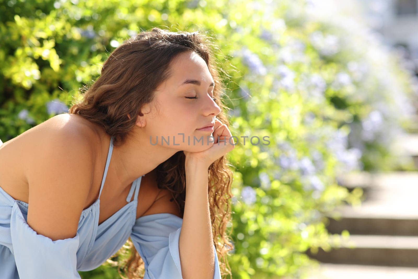 Happy woman relaxing in a green garden street