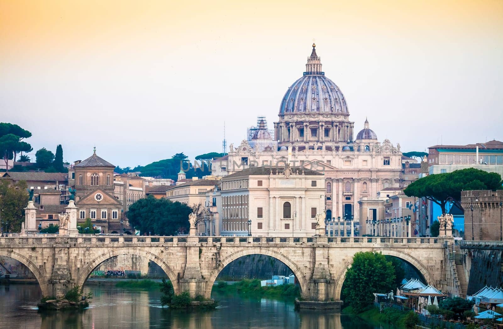 ROME, ITALY - JUNE 2020: sunset panorama on Tiber river bridge with Saint Peter Cathedral dome (Vatican City) in background - Rome, Italy