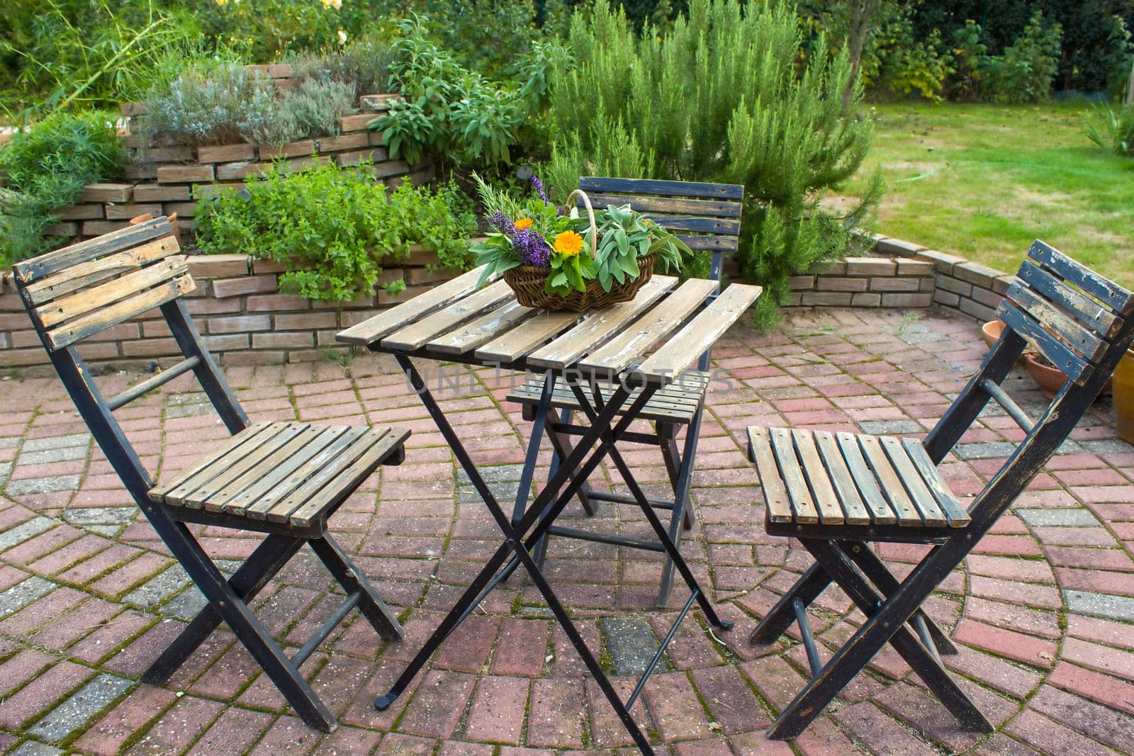 herb spiral in the garden and table with chairs