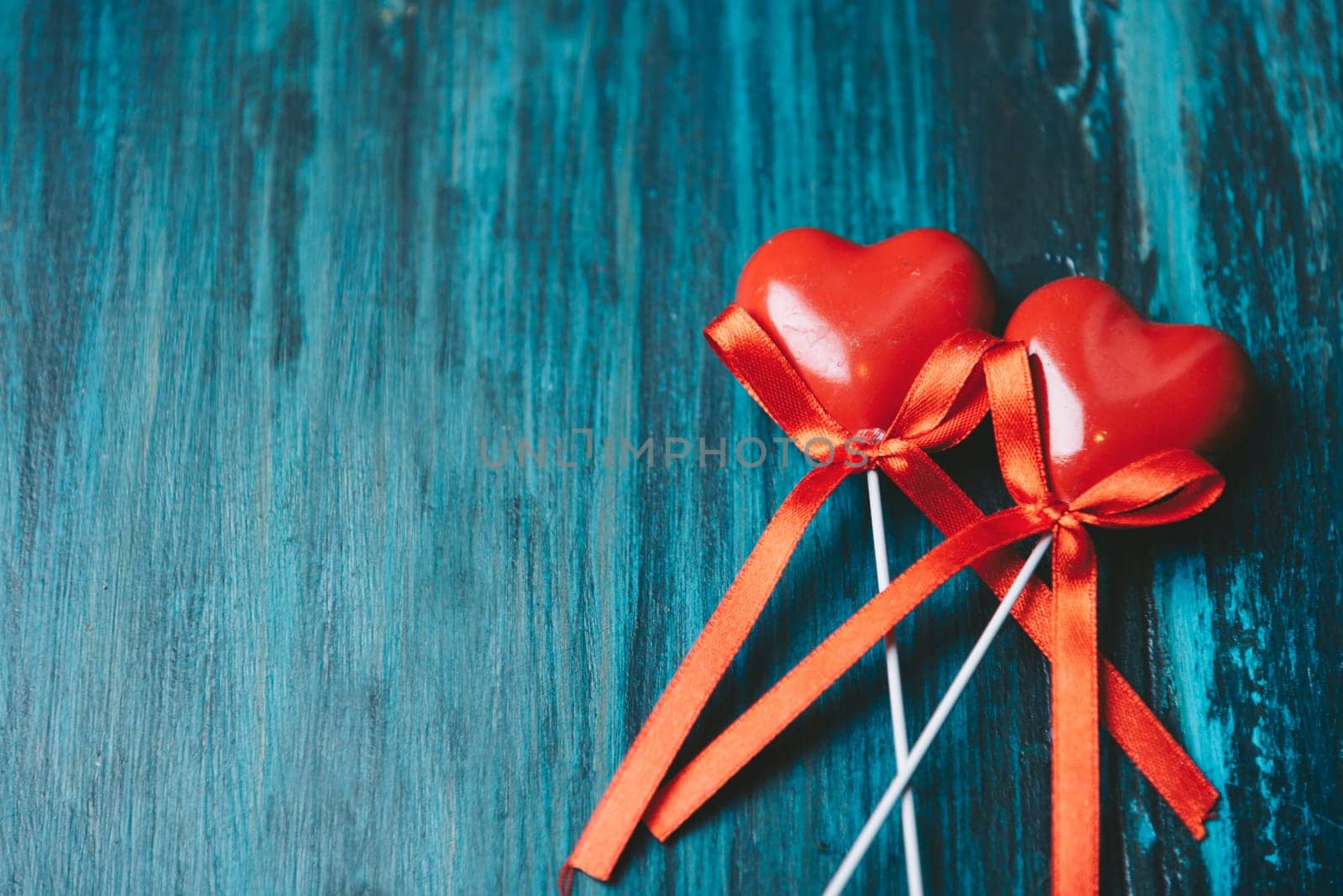 Valentine's day design with two red love hearts on blue texture wooden background with copyspace. Retro filter.