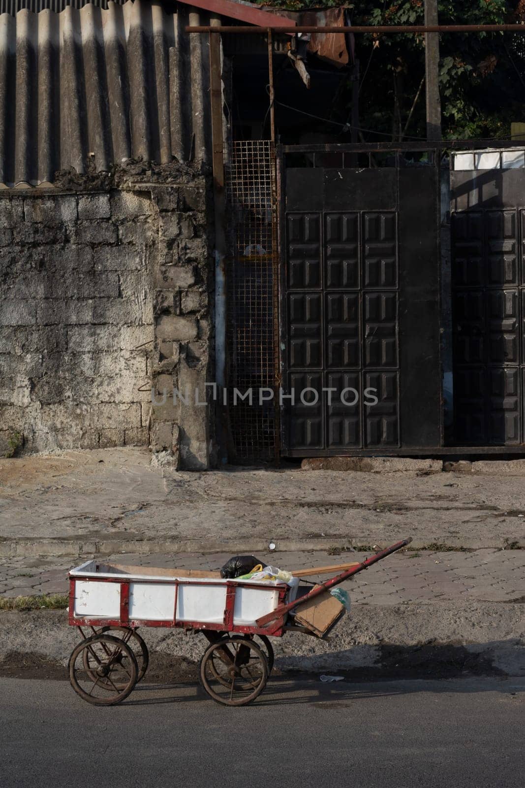 Handcart at street in front of buildings- urban scene