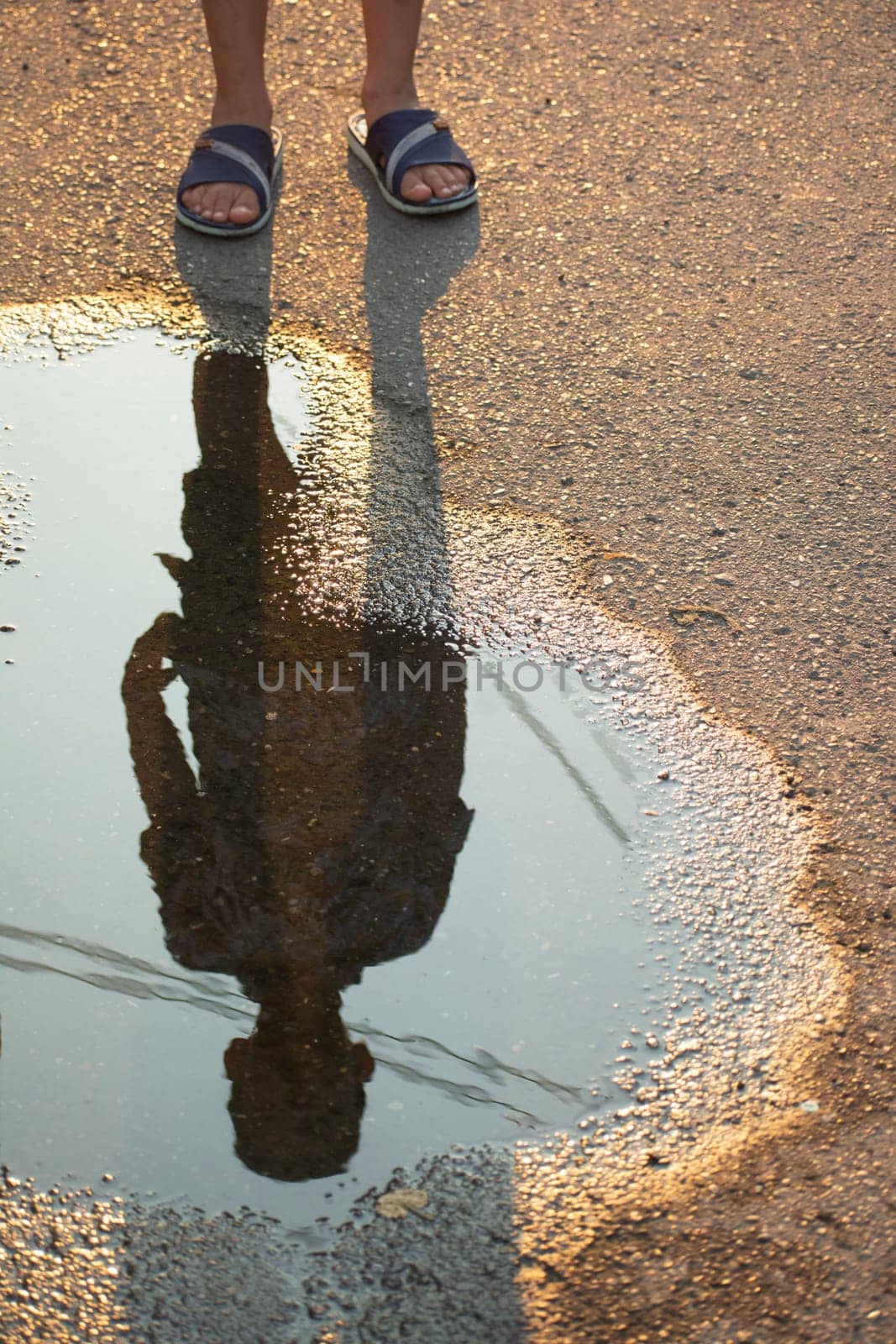 silhouette of a kid on a small pond at street