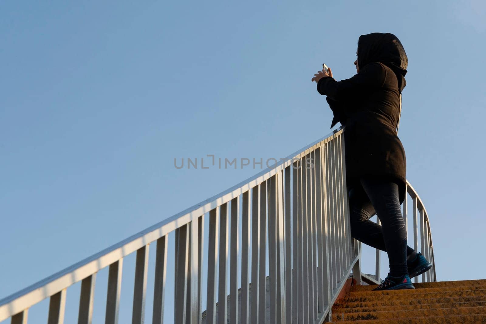 Muslim young woman taking photo by cellphone