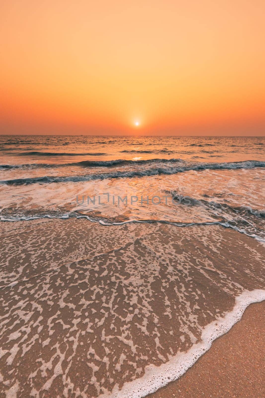 Sunset Sun Above Sea. Natural Sunrise Sky Warm Colors Over Ripple Sea. Ocean Water Foam Washing Sandy Beach At Sunset.