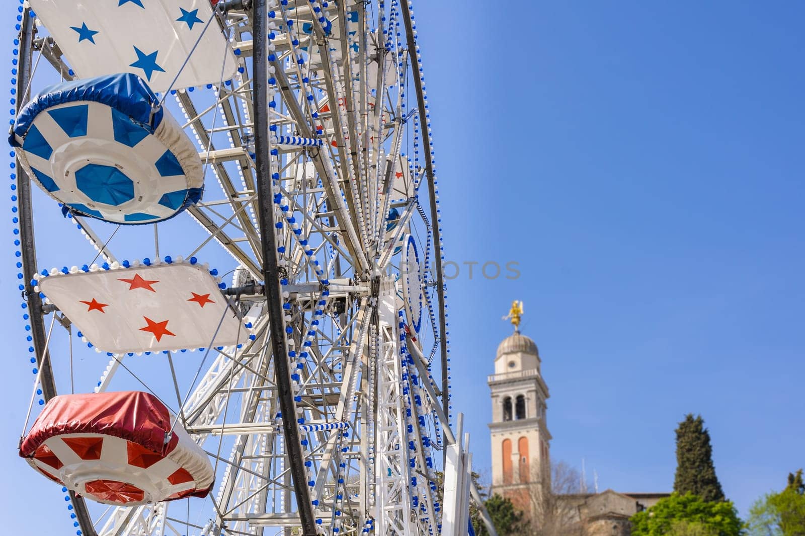Ferris Wheel at the county fair with the sky in the background and a bell tower