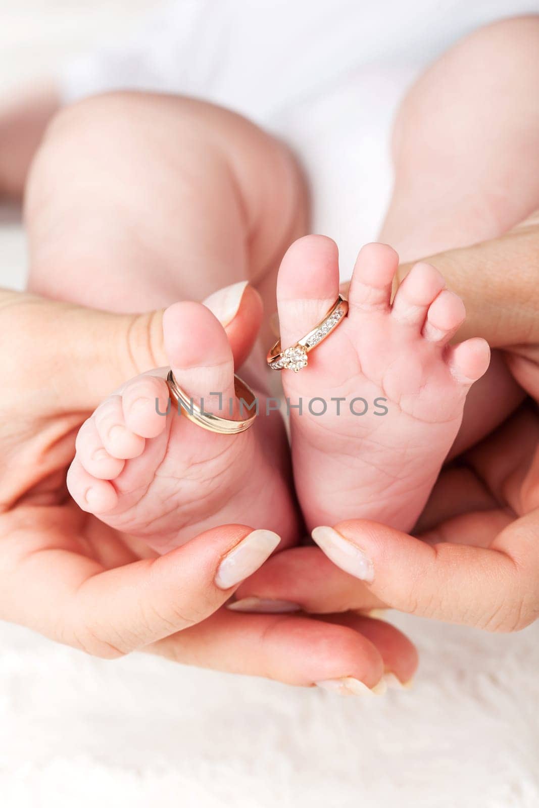 Baby feet with wedding rings - parenting concept