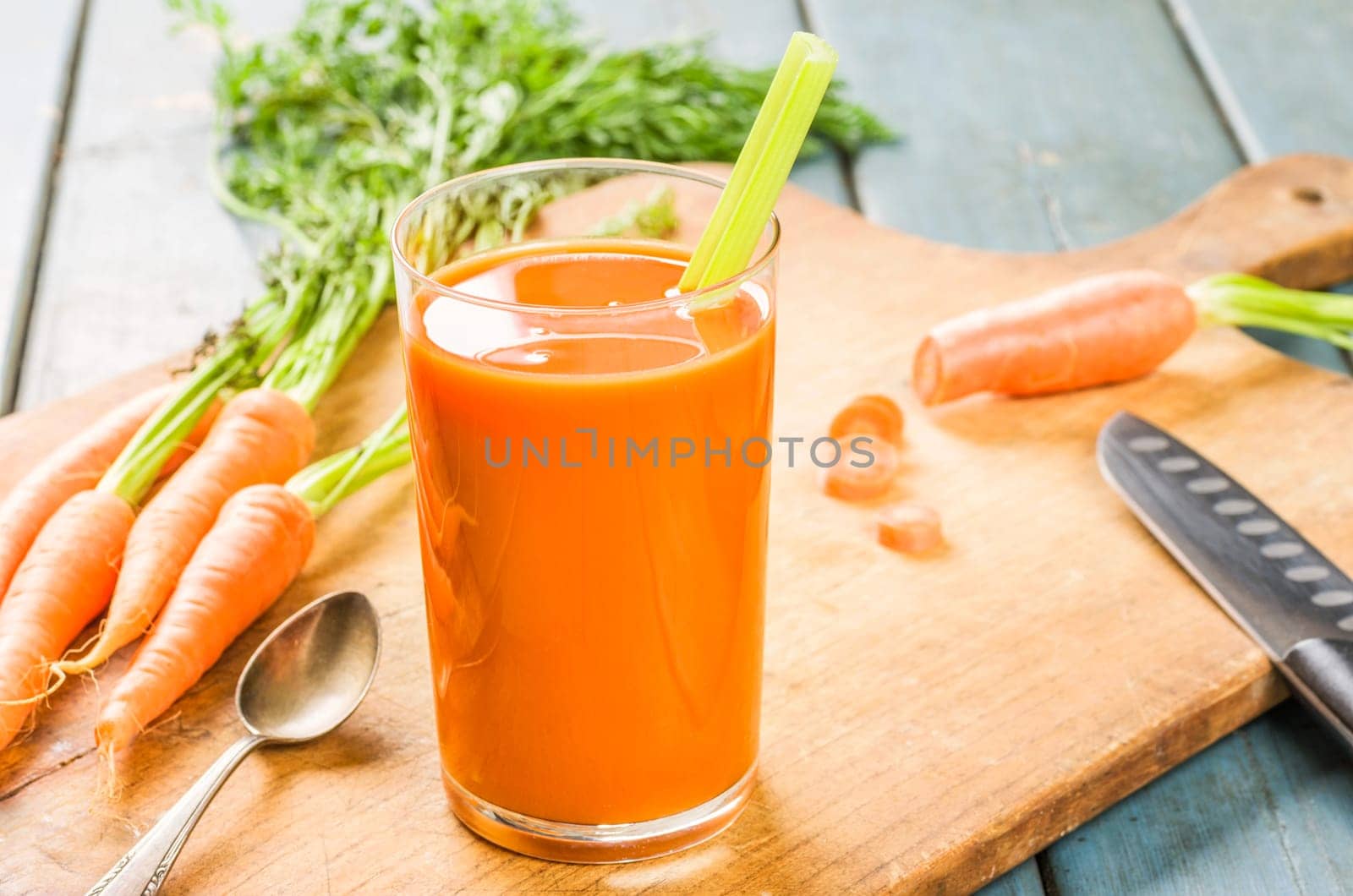 A glass of carrot juice with fresh carrots