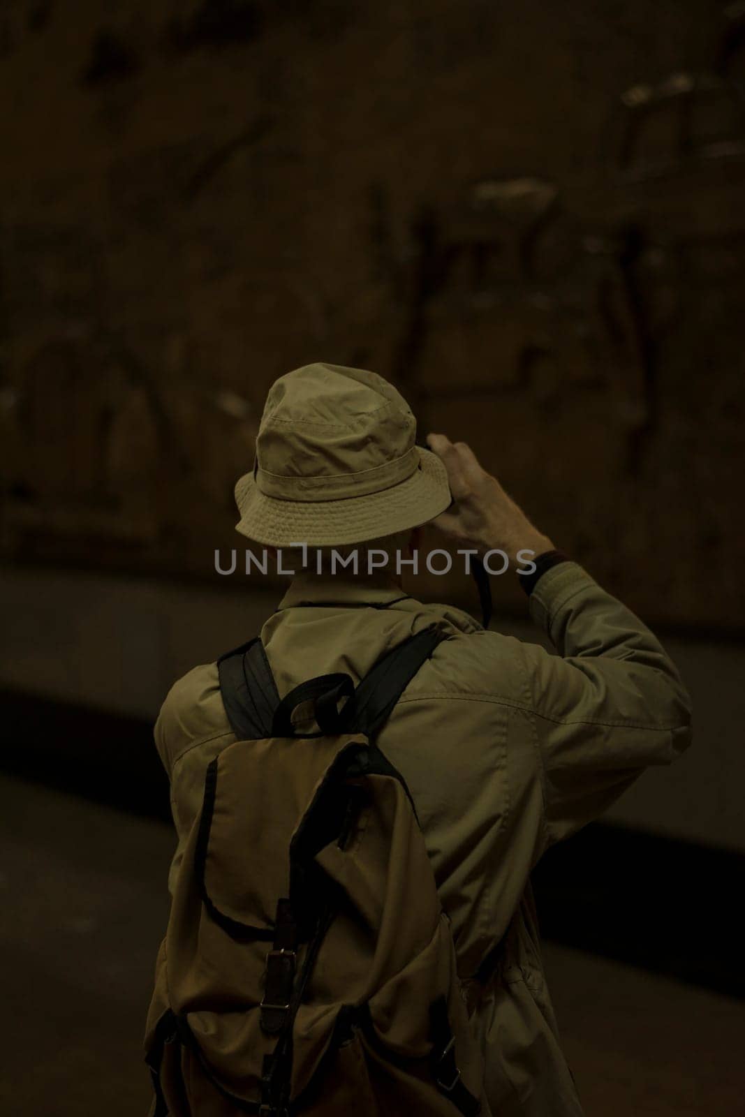 Rear view of a man taking photos from underground emboss