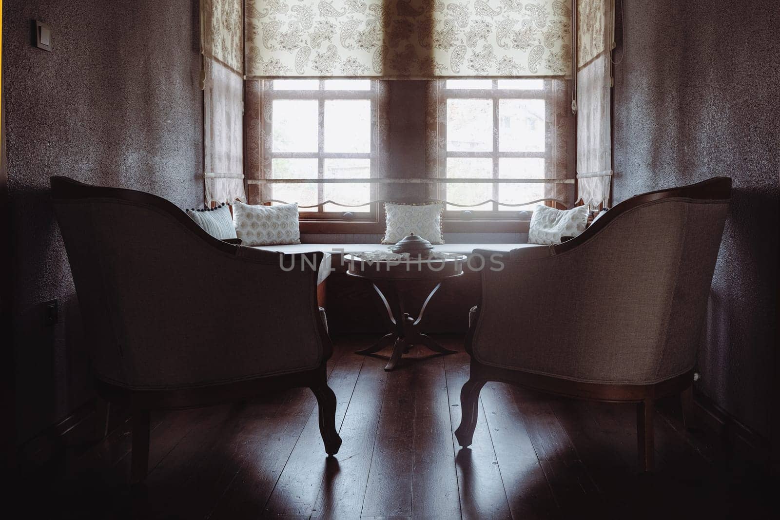 front view of divan with several pillows in front of window
