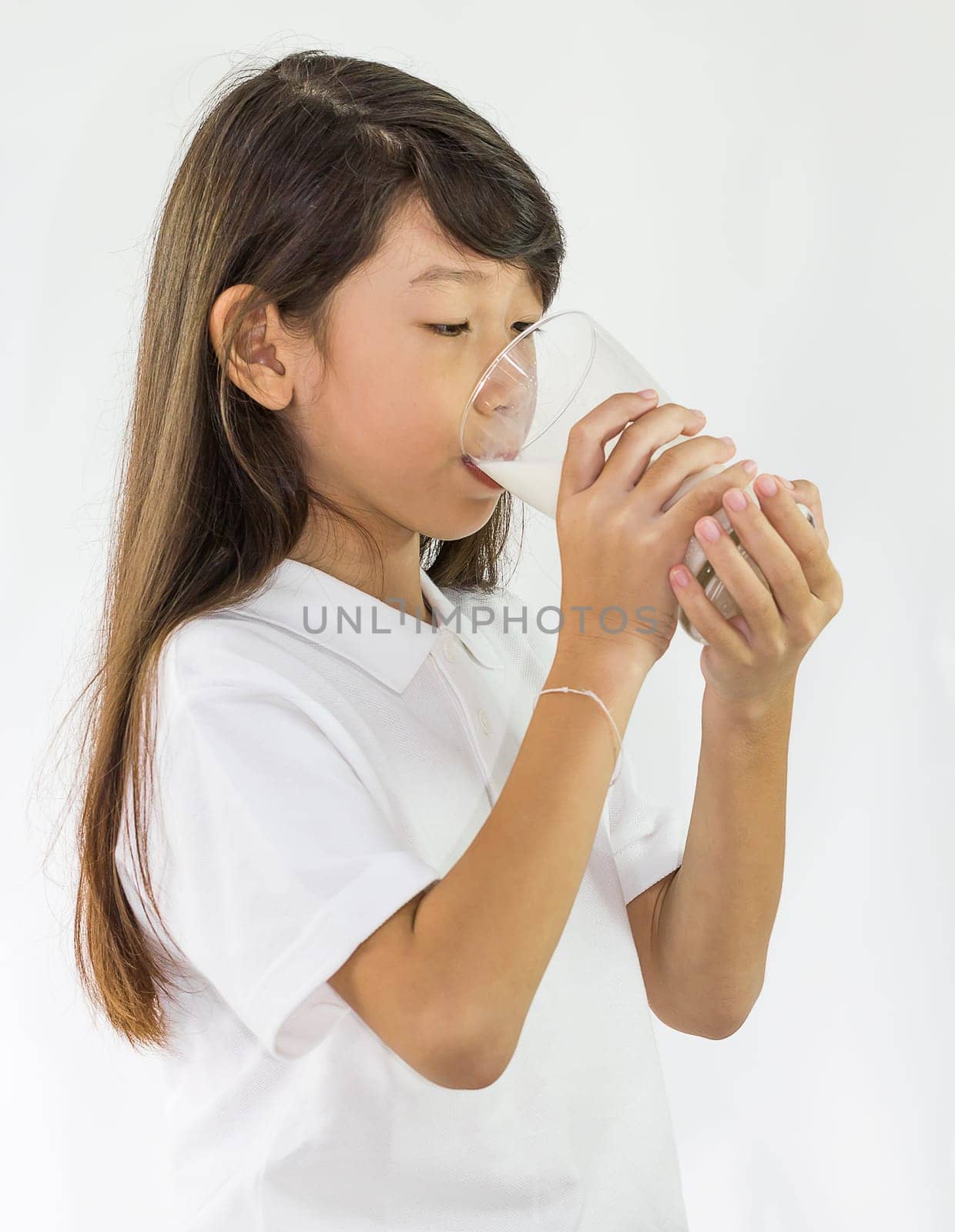Young girl drinking milk in Studio on white