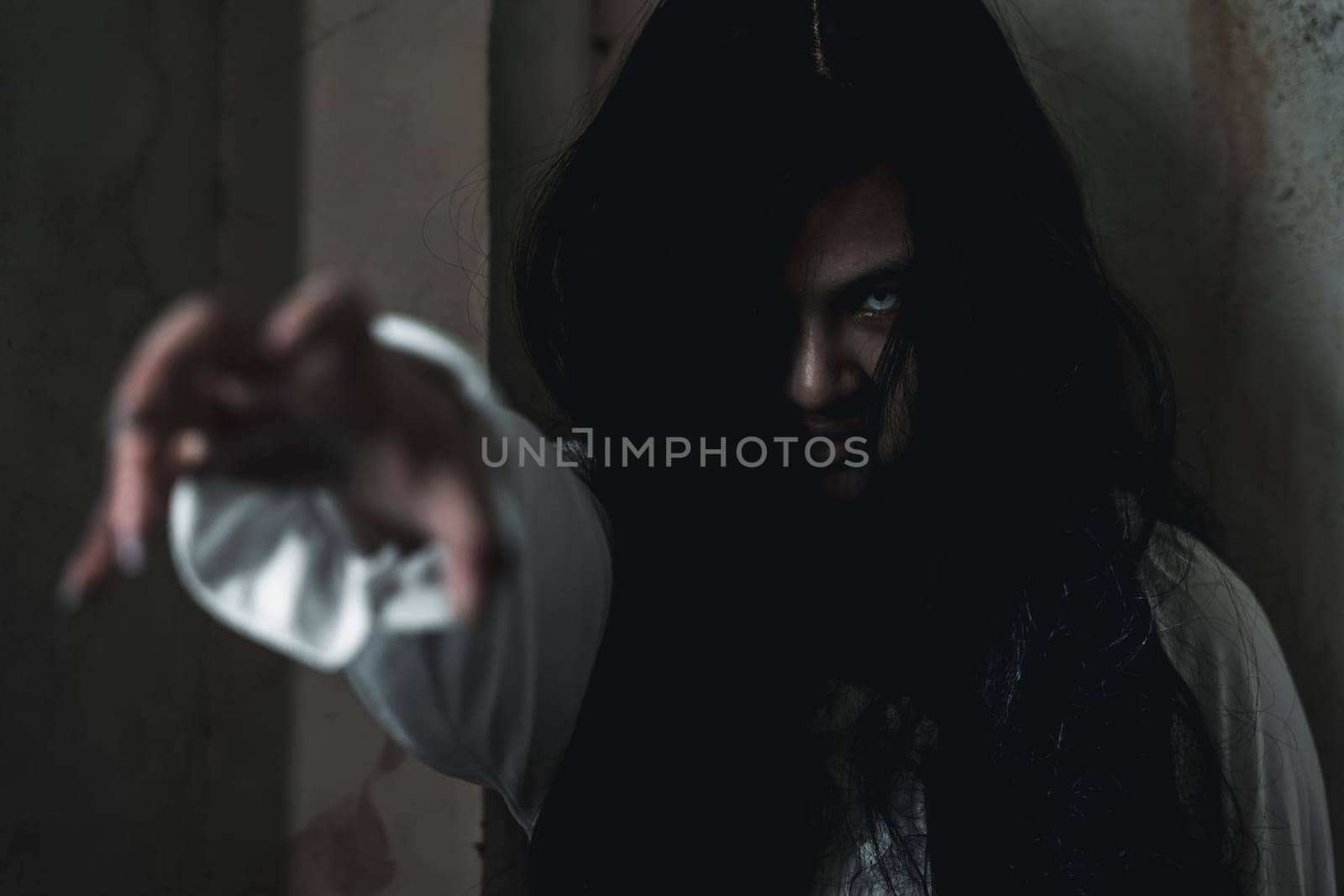 Scary ghost woman. Asian ghost or zombie horror creepy scary have hair covering face and eye reach arm out at abandoned house dark room, female makeup terror zombie face, Happy Halloween day concept