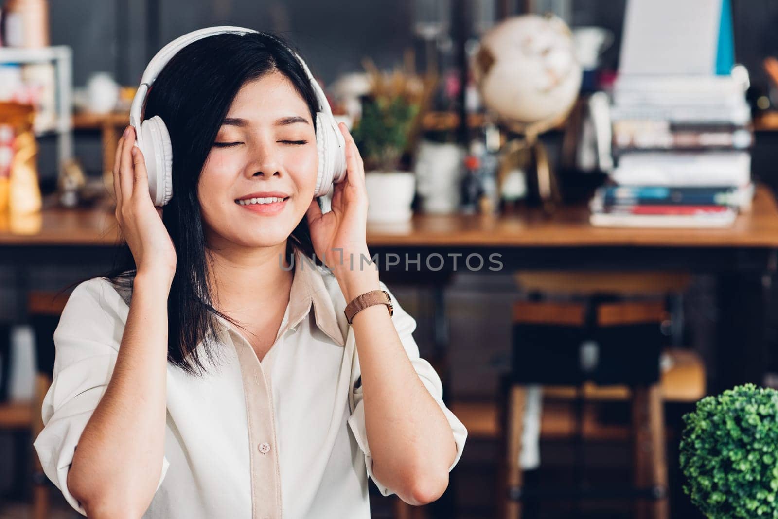 Business women lifestyle freelance sitting alone he using earphones listening music new song during working on laptop computer in coffee cafe shop, Student girl coffee break while doing homework