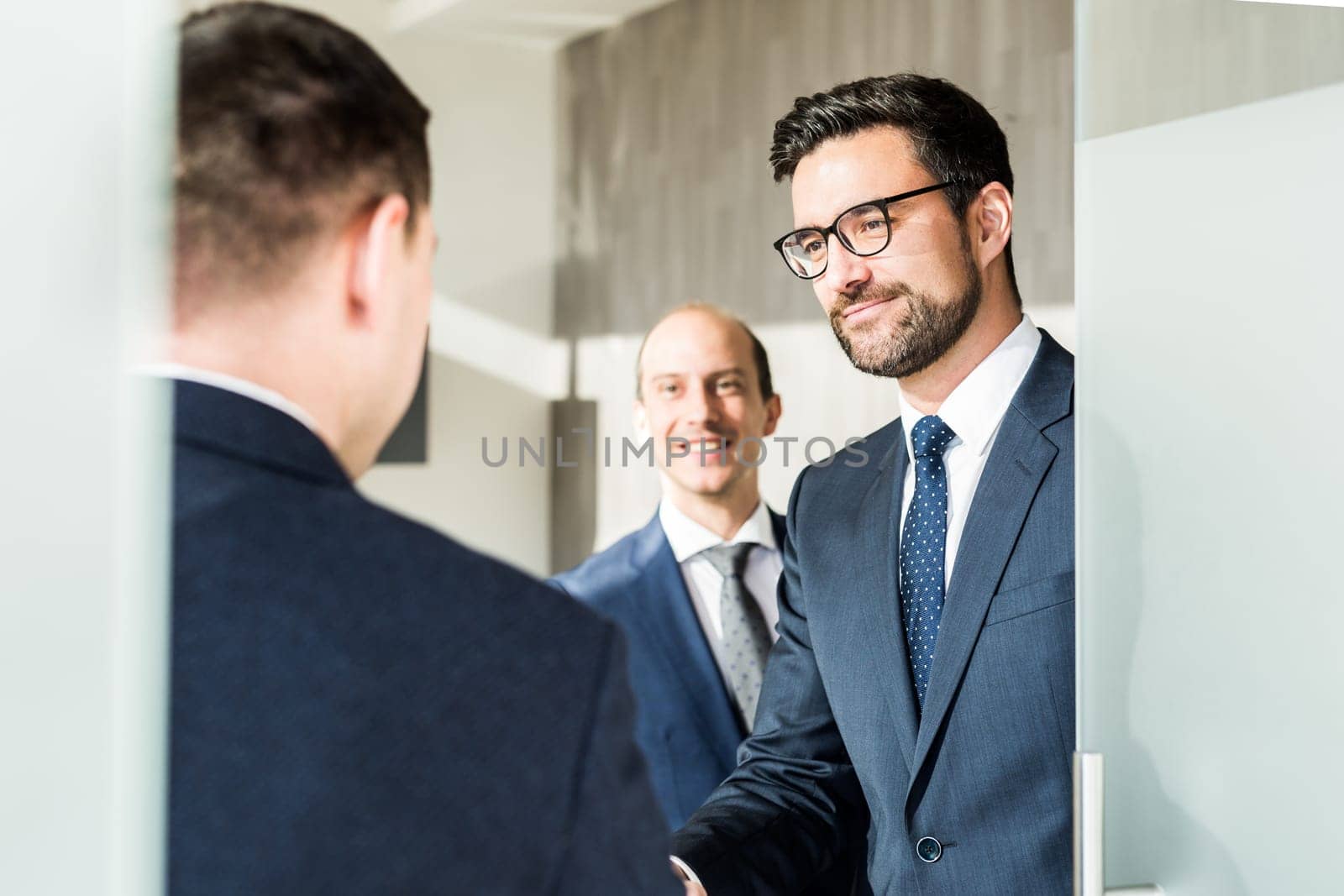 Group of confident business people greeting with a handshake at business meeting in modern office. Closing the deal agreement by shaking hands. Business and entrepreneurship success concept.