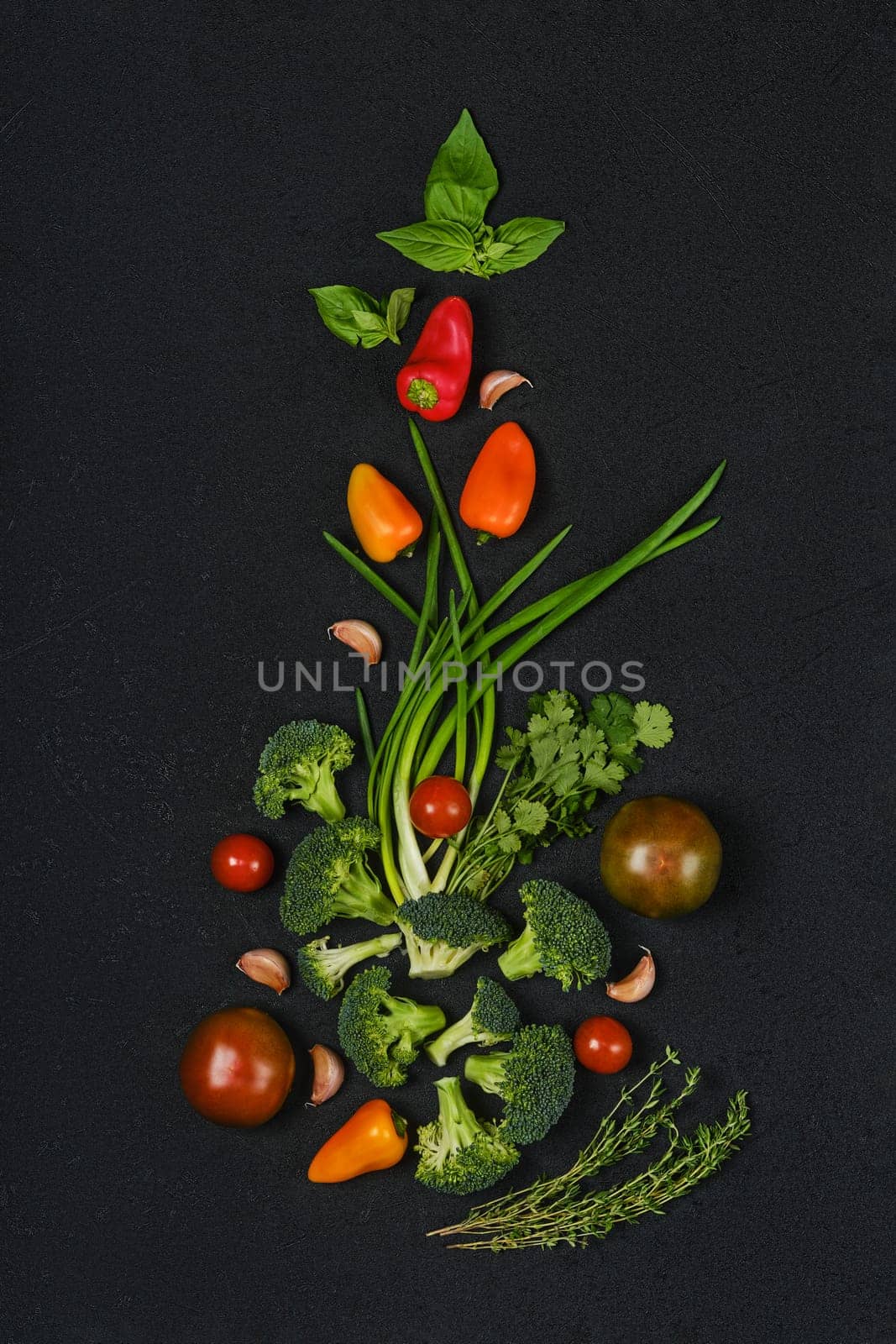 Overhead composition with fresh spring onion, tomato, broccoli, bell pepper, thyme, basil and garlic