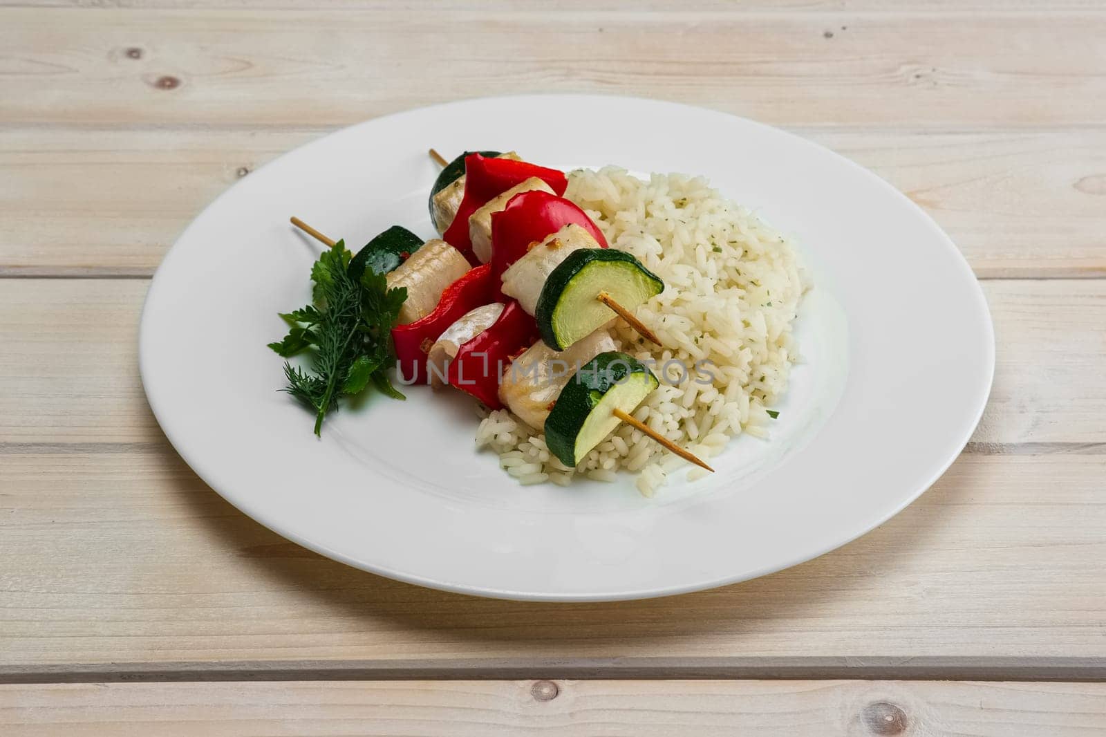 Grilled fish and vegetables on skewer with boiled rice